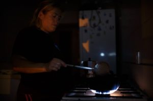 Mujer cocinando en su casa sin luz 
